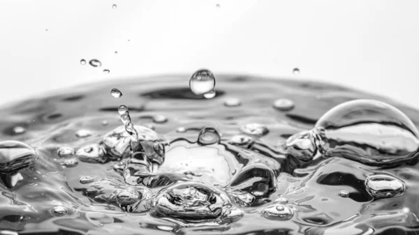 Gotas de agua en una superficie de agua — Foto de Stock