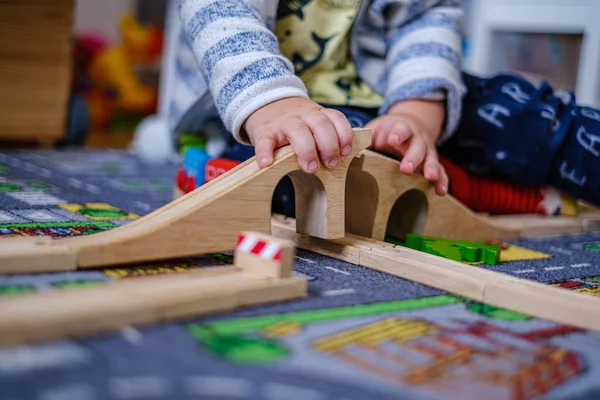 Bir ca ahşap raylar üzerinde ahşap tren seti ile oynayan bebek elleri — Stok fotoğraf