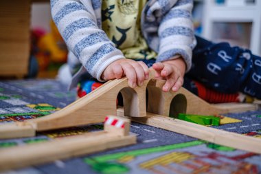 bir ca ahşap raylar üzerinde ahşap tren seti ile oynayan bebek elleri