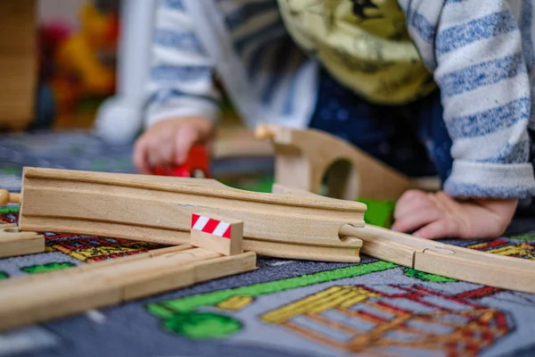 Dětské ruce si hrají s dřevěnou vlakovým zábradlím na dřevěné kolejnicích na CA — Stock fotografie