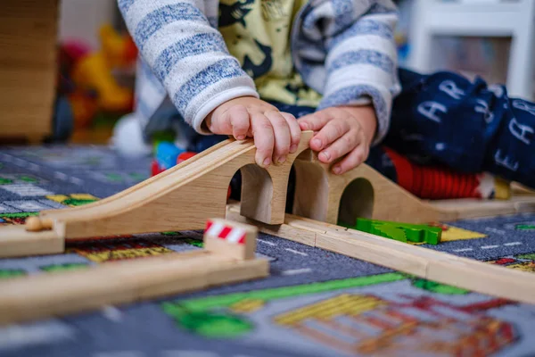 Baby-Hände spielen mit Holzzug auf Holzschienen auf einem ca. — Stockfoto
