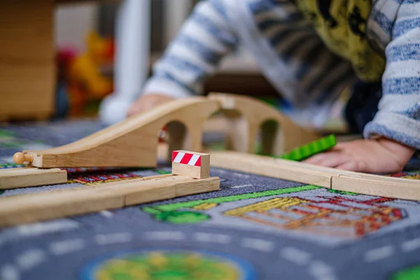 Baby-Hände spielen mit Holzzug auf Holzschienen auf einem ca. — Stockfoto
