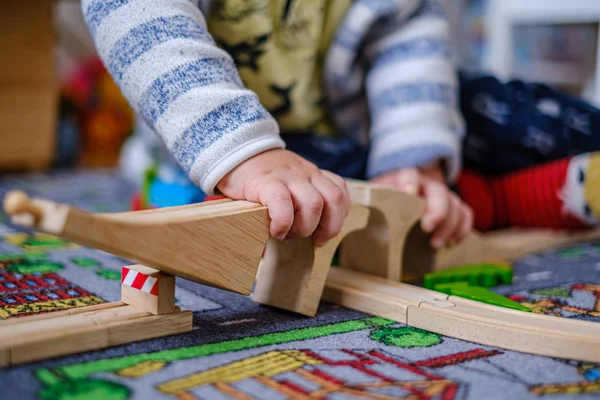 Bir ca ahşap raylar üzerinde ahşap tren seti ile oynayan bebek elleri — Stok fotoğraf