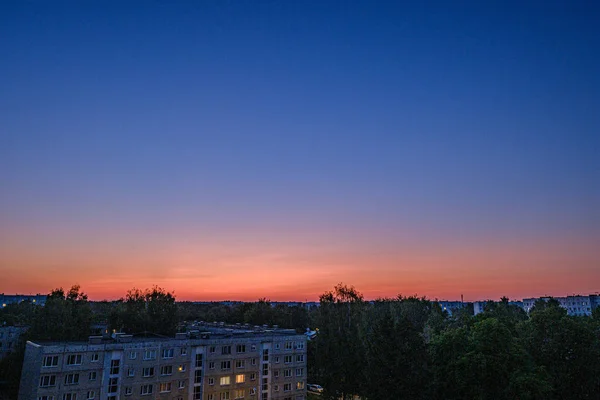 Rode zonsondergang over stad met huisvesting en internetprovider kabels i — Stockfoto