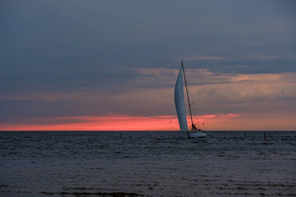 Jacht segelt im Meer auf Wellen bei Sonnenuntergang — Stockfoto