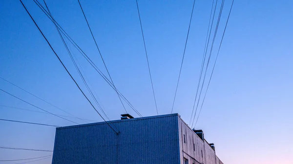 Pôr do sol vermelho sobre a cidade com habitação e cabos provedor de internet i — Fotografia de Stock