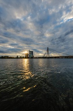 Letonya 'daki Riga şehrinin panoramik görüntüsü. Akşamüstü Letonya 'nın başkenti, kırmızı gün batımı ve Daugava nehri.