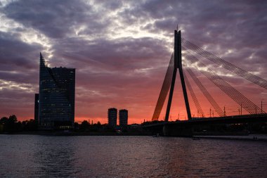 Letonya 'daki Riga şehrinin panoramik görüntüsü. Akşamüstü Letonya 'nın başkenti, kırmızı gün batımı ve Daugava nehri.