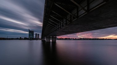 Letonya 'daki Riga şehrinin panoramik görüntüsü. Akşamüstü Letonya 'nın başkenti, kırmızı gün batımı ve Daugava nehri.