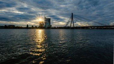 Letonya 'daki Riga şehrinin panoramik görüntüsü. Akşamüstü Letonya 'nın başkenti, kırmızı gün batımı ve Daugava nehri.