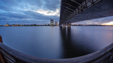 Letonya 'daki Riga şehrinin panoramik görüntüsü. Akşamüstü Letonya 'nın başkenti, kırmızı gün batımı ve Daugava nehri.
