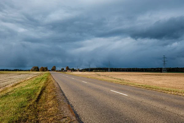 Nuvens de tempestade sobre estrada de asfalto em perspectiva — Fotografia de Stock