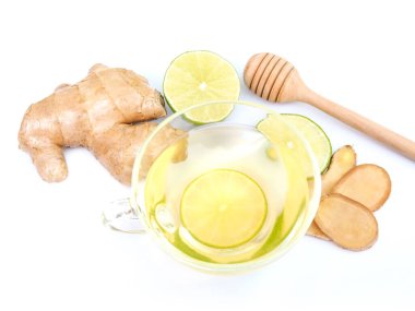Beyaz arka planda izole edilmiş limonlu zencefilli çay ve ballı fincanda sağlıklı bitkisel içecek..
