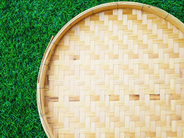 Bamboo weave trays container for Thai food on green grass with copy space for design.