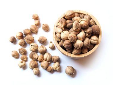 Kurutulmuş baharat ve otların üst görüntüsü siam kakule ya da beyaz arka planda izole edilmiş ahşap kase içindeki amomum krervanh pierre..