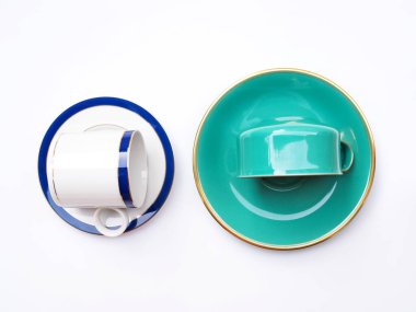 Kahve fincanlarının ya da çay fincanlarının beyaz arka planda izole edilmiş fincan tabağına yerleştirilmiş üst görünümü.