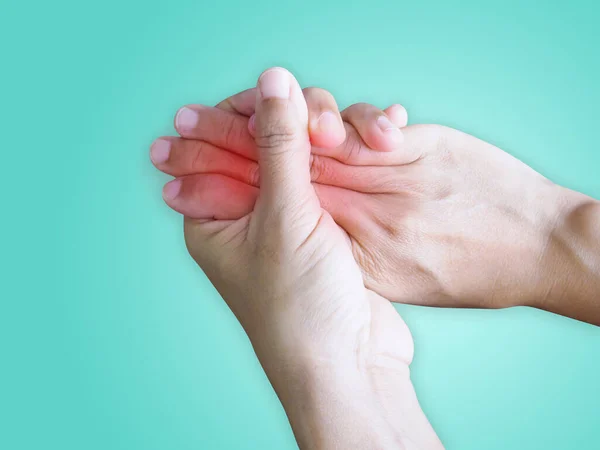 Close-up on hand suffering with joint pain and finger injury isolated on green background