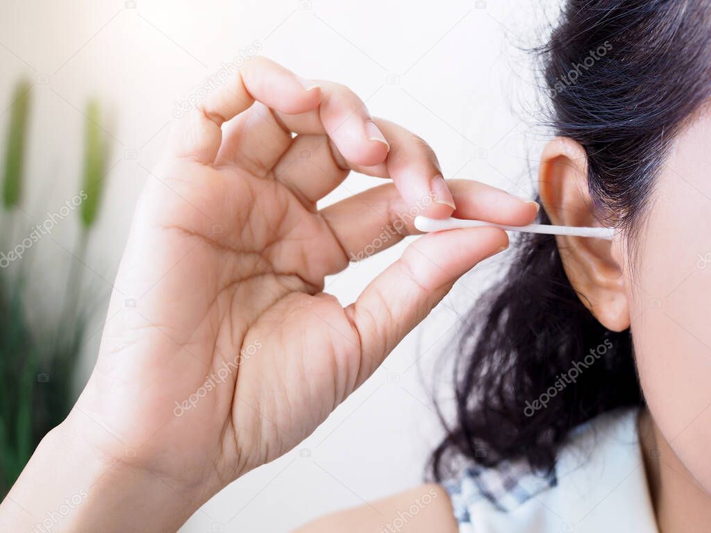 Asian women clean of ears with cotton bud for good health.