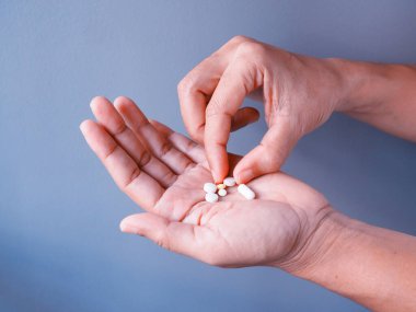 Mavi arka planda ilaç hapları ile hastalıktan ilaç almak.    