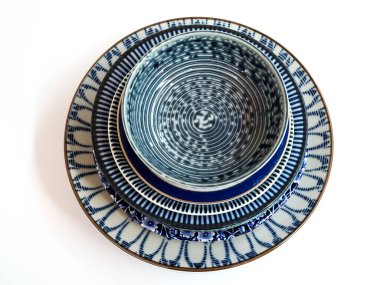 Beyaz arka planda izole edilmiş seramik porselen çanak ve kase setinin üst görüntüsü.