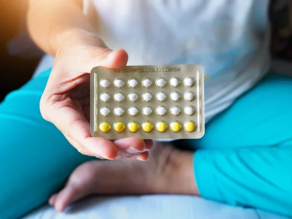 Elinde bir paket hap, doğum kontrol hapı ya da kadınlar için doğum kontrol hapı olan bir kadın..