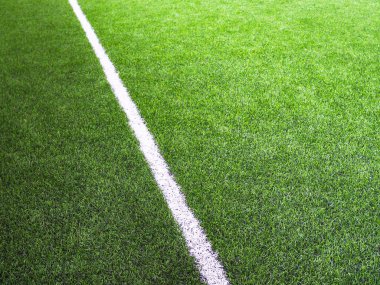 Futbol sahasında ya da futsal sahasında yeşil çimlerde beyaz çizgi.