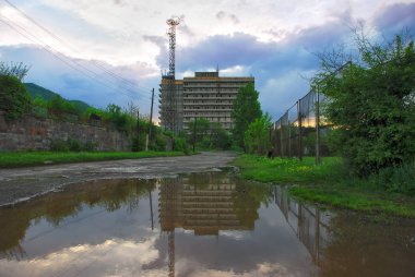 Vanadzor, Ermenistan. Su birikintisi su bina yansıması.