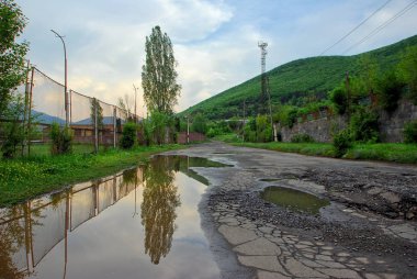 Vanadzor, Ermenistan. Su birikintisi su bina yansıması.