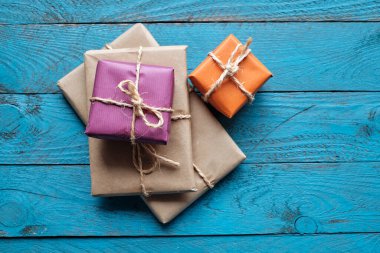 Mavi rustik ahşap zemin üzerine kraft kağıdı hediye paketleri
