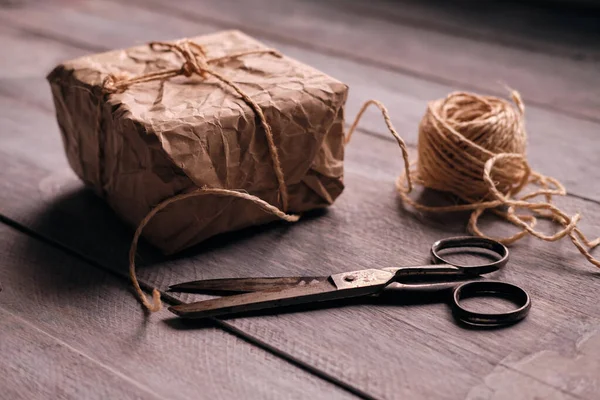 Geschenkpaket Aus Kraftpapier Seil Und Schere Auf Rustikalem Holztisch — Stockfoto