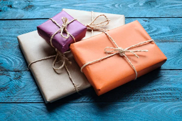 Mavi rustik ahşap zemin üzerine kraft kağıdı hediye paketleri