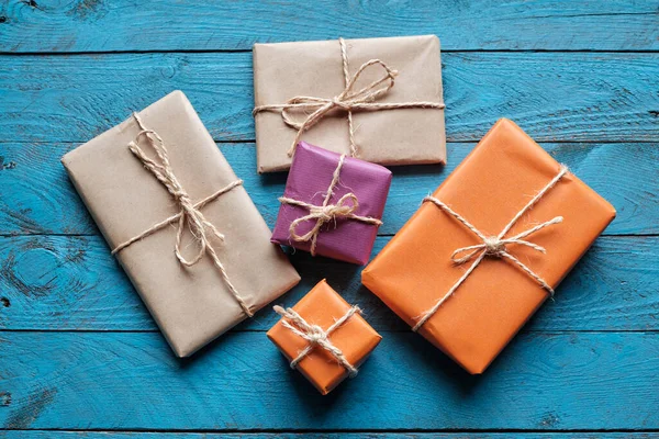 Mavi rustik ahşap zemin üzerine kraft kağıdı hediye paketleri