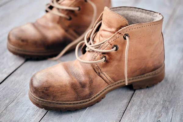 Kırsal ahşap arka planda eski kahverengi çizmeler