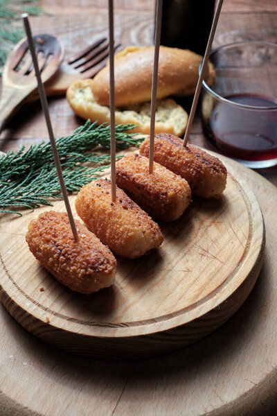 Chicken croquettes pricked with toothpick on wooden board