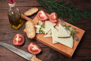 Dilimlenmiş koyun peyniri ve domates parçaları.
