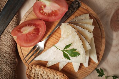 Dilimlenmiş koyun peyniri ve domates parçaları.