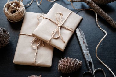 Kraft kağıdına sarılı hediye paketleri ve ananaslarla çevrili.