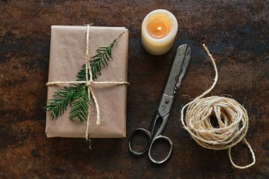 Kırsal seramik üzerinde Kraft kağıdı ve makas ile sarılı hediye paketi