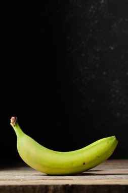 Metin için dikey siyah arkaplan ve boşluk olan yeşil muz