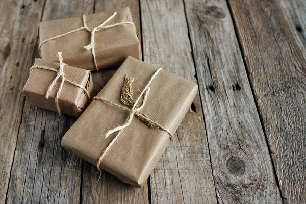 Geschenkpakete Mit Kraftpapier Umwickelt Und Mit Seil Auf Rustikalem Holztisch — Stockfoto