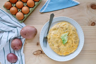 Köy ahşap masa üzerinde çiğ malzemeli İspanyol patates omleti.