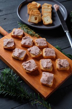 Siyah ahşap masada küçük tostlar üzerinde ezme