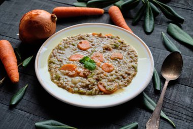 Siyah masada havuçlu, soğanlı ve biberli pişmiş mercimek tabağı.