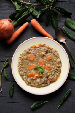 Siyah masada havuçlu, soğanlı ve biberli pişmiş mercimek tabağı.