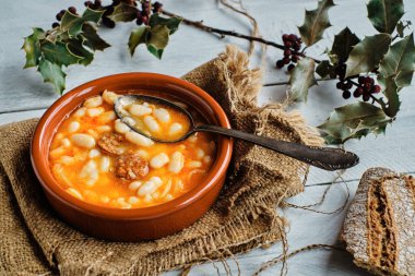 Kil çömlek ve kırsal arka planda sucuklu fasulye pişirdim.