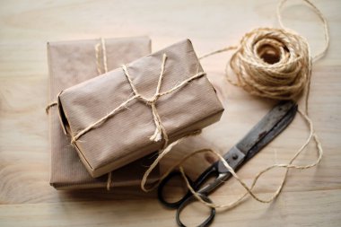 Tahta masa üzerinde kraft kağıdına sarılı hediye paketleri