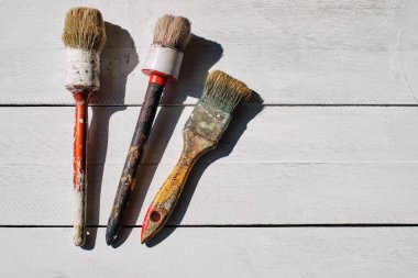 Beyaz masa üzerinde beyaz boya izleri olan eski fırçalar.