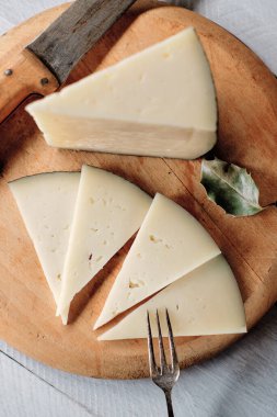 Bıçak ve çatalla yarı pişmiş koyun peyniri.