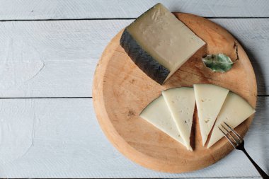 Bıçak ve çatalla yarı pişmiş koyun peyniri.