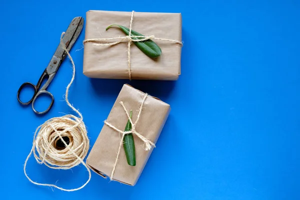 Geschenkpakete Kraftpapier Schere Und Seil Auf Blauem Hintergrund — Stockfoto